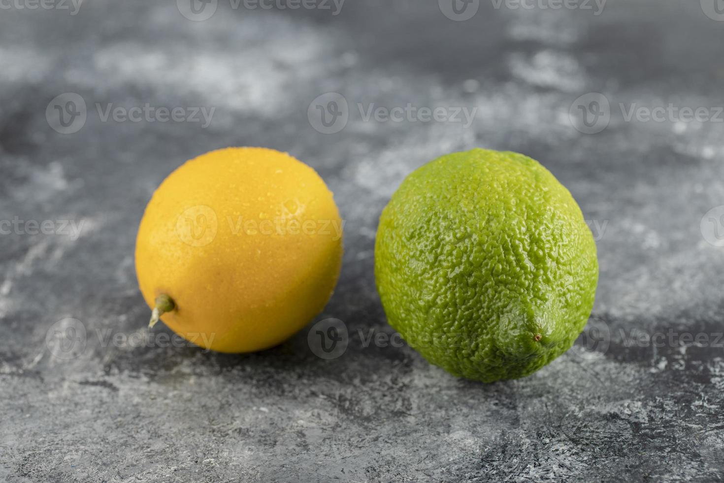 limoni gialli e verdi su fondo di marmo foto