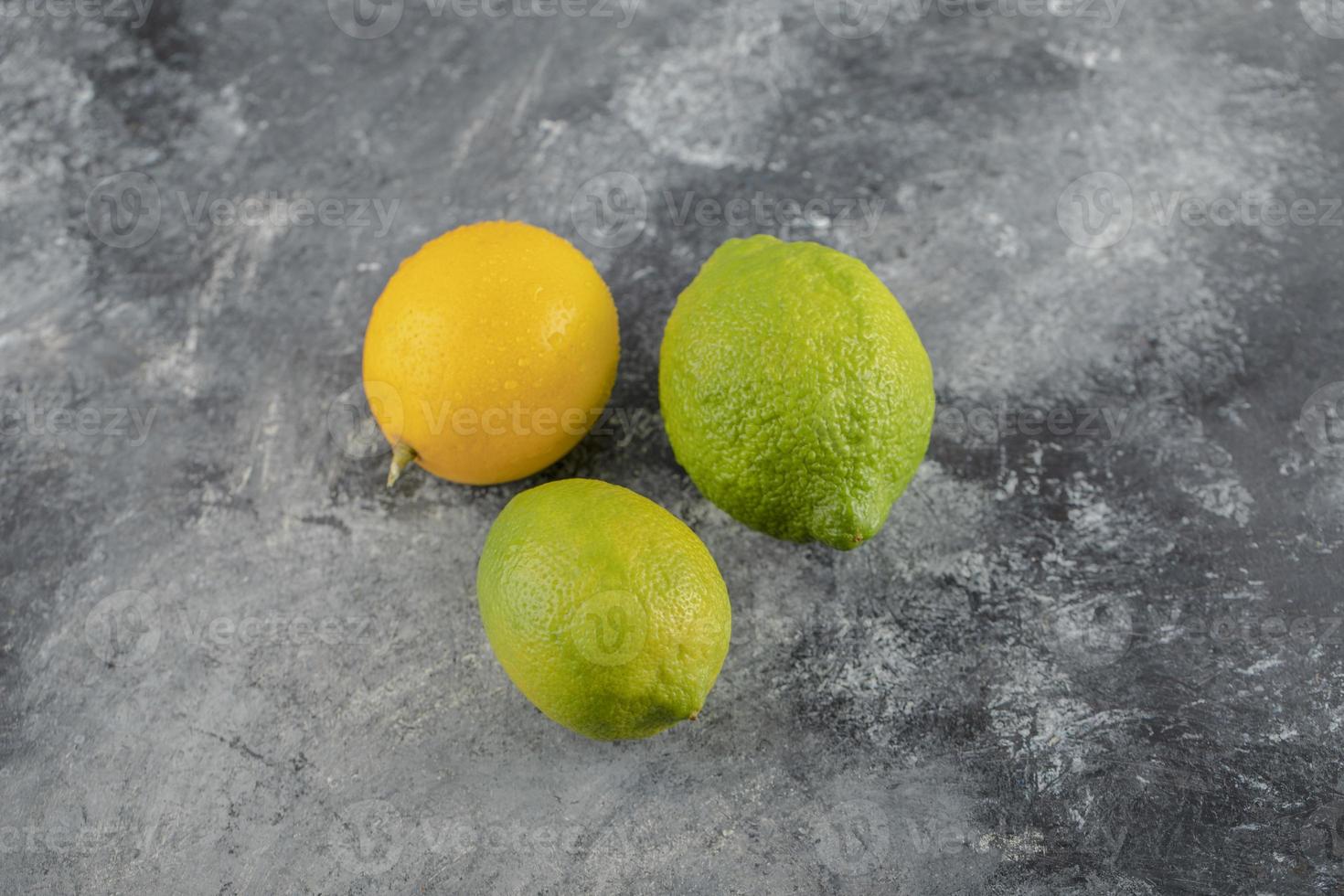 limoni gialli e verdi su fondo di marmo foto