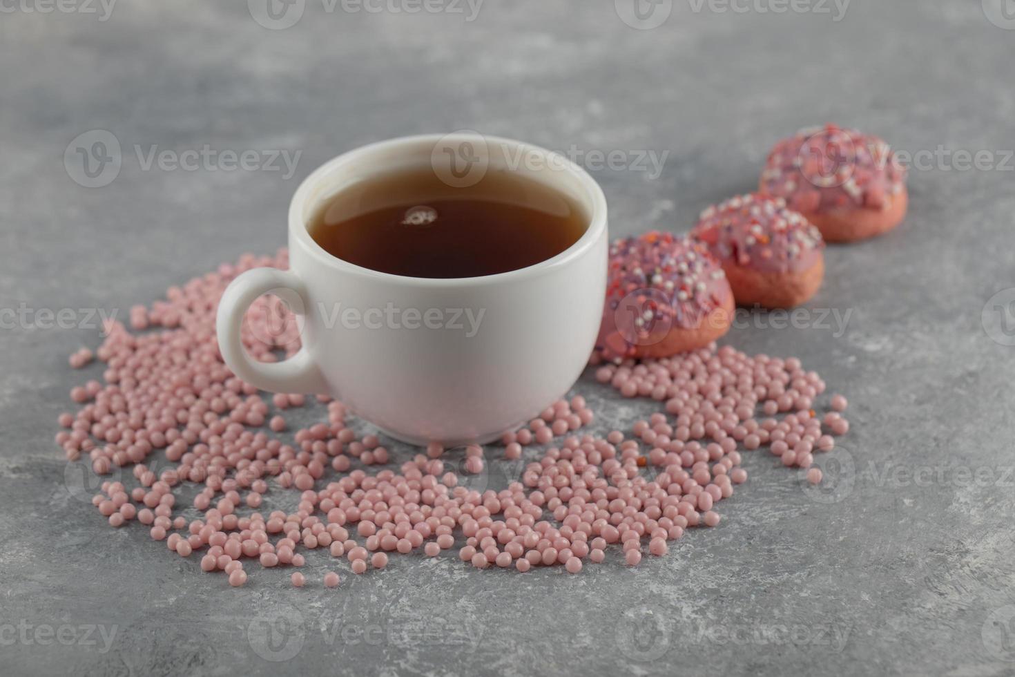 ciambelle dolci rosa con una tazza di tè foto