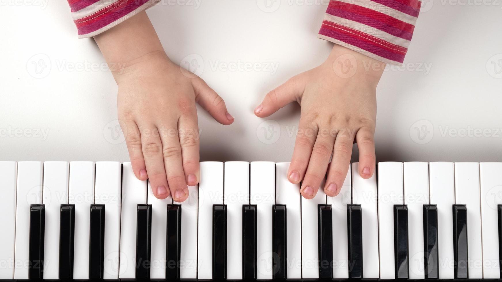 le mani del bambino su una tastiera foto