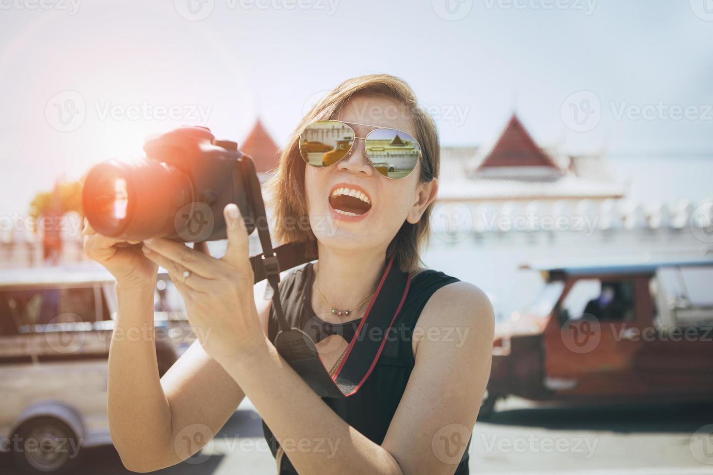 felicità viso di asiatico donna Tenere dslr telecamera in piedi nel vecchio cittadina di ayutthaya mondo eredità luogo di unesco Tailandia foto