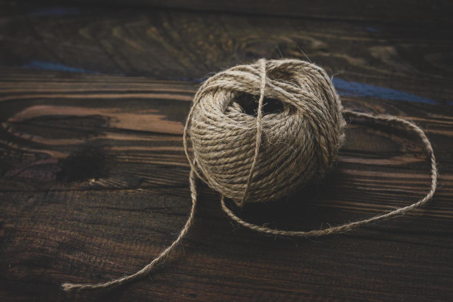 Marrone lana filato palla isolato su di legno sfondo. palla di filato per maglieria foto
