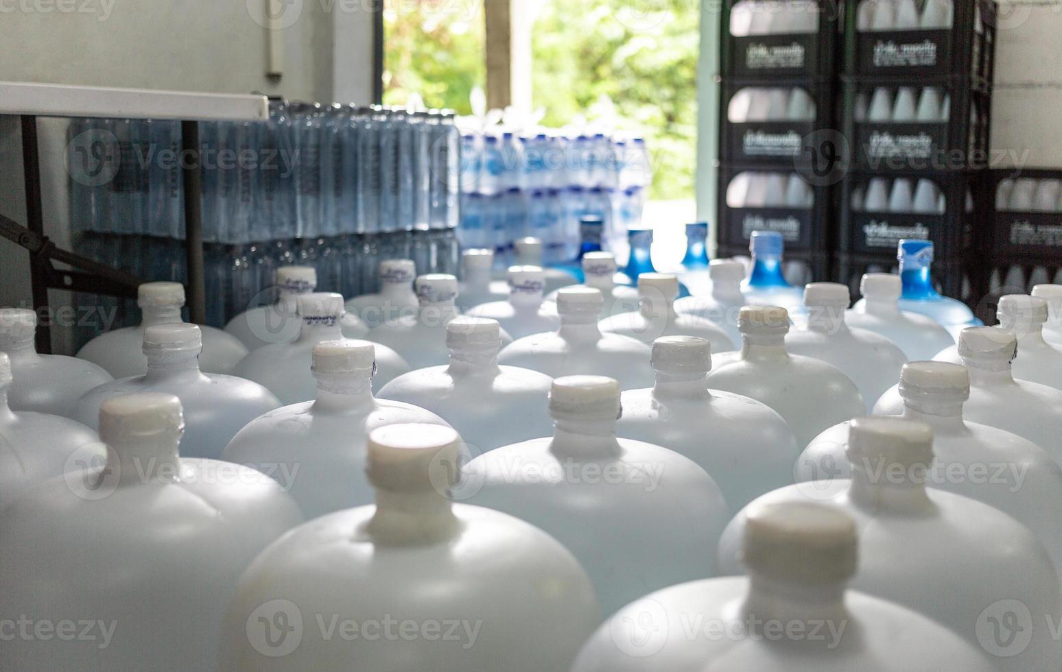 molte di acqua bianca gallone. gallone con bianca cappucci. imbottigliamento pianta-acqua imbottigliamento linea per in lavorazione e imbottigliamento bevanda acqua in bottiglie. potabile acqua attività commerciale foto