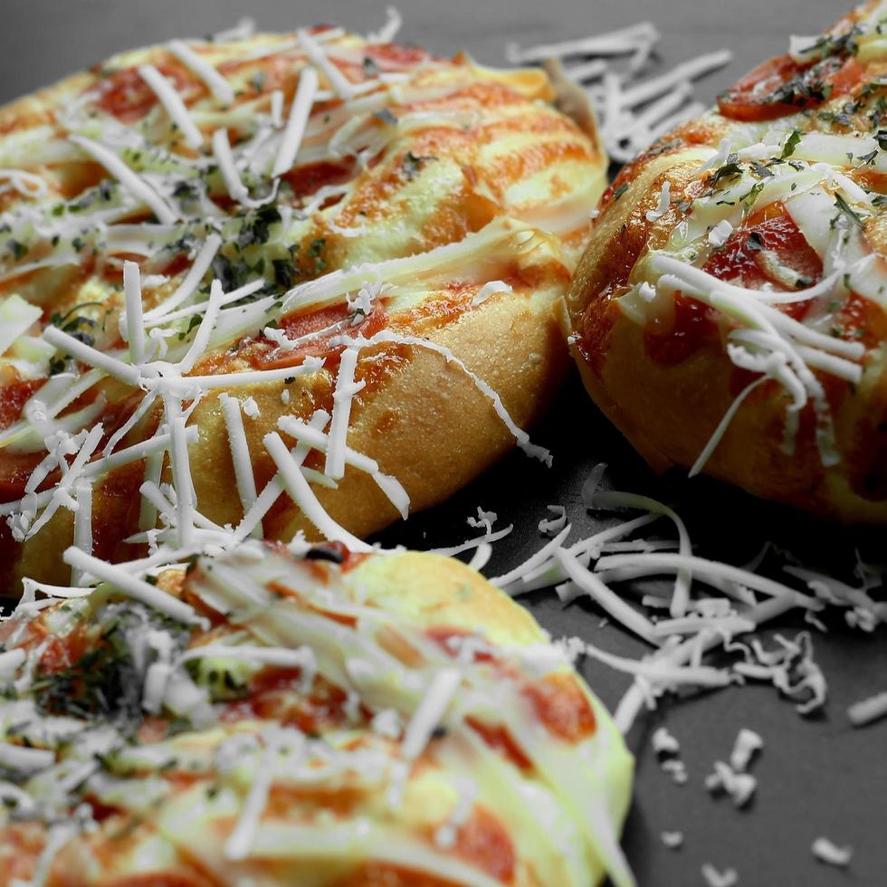 mini Pizza sormontato con grattugiato formaggio e alcuni carne foto
