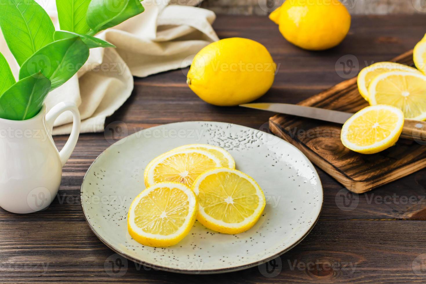 il giro pezzi di maturo limoni su un' piatto e su un' di legno taglio tavola su il tavolo. biologico nutrizione, fonte di vitamine. foto