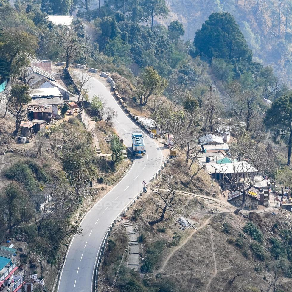 vista aerea dall'alto dei veicoli stradali che guidano su strade di montagna a nainital, india, uttarakhand, vista dal lato superiore della montagna per il movimento di veicoli stradali foto