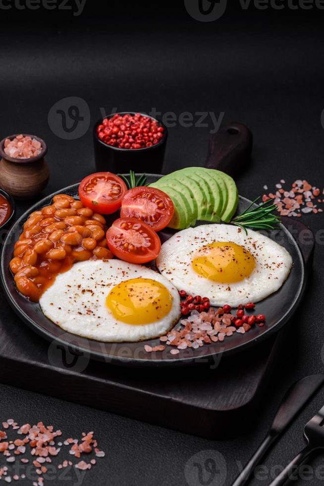 delizioso nutriente inglese prima colazione con fritte uova, pomodori e avocado foto