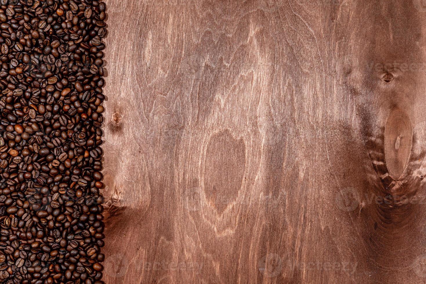 strisce di chicchi di caffè su sfondo texture in legno scuro, copia spazio per il testo foto