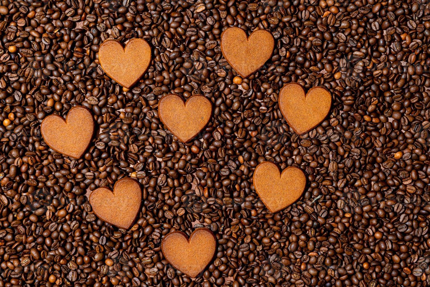 biscotti di panpepato a forma di cuore sullo sfondo di chicchi di caffè foto