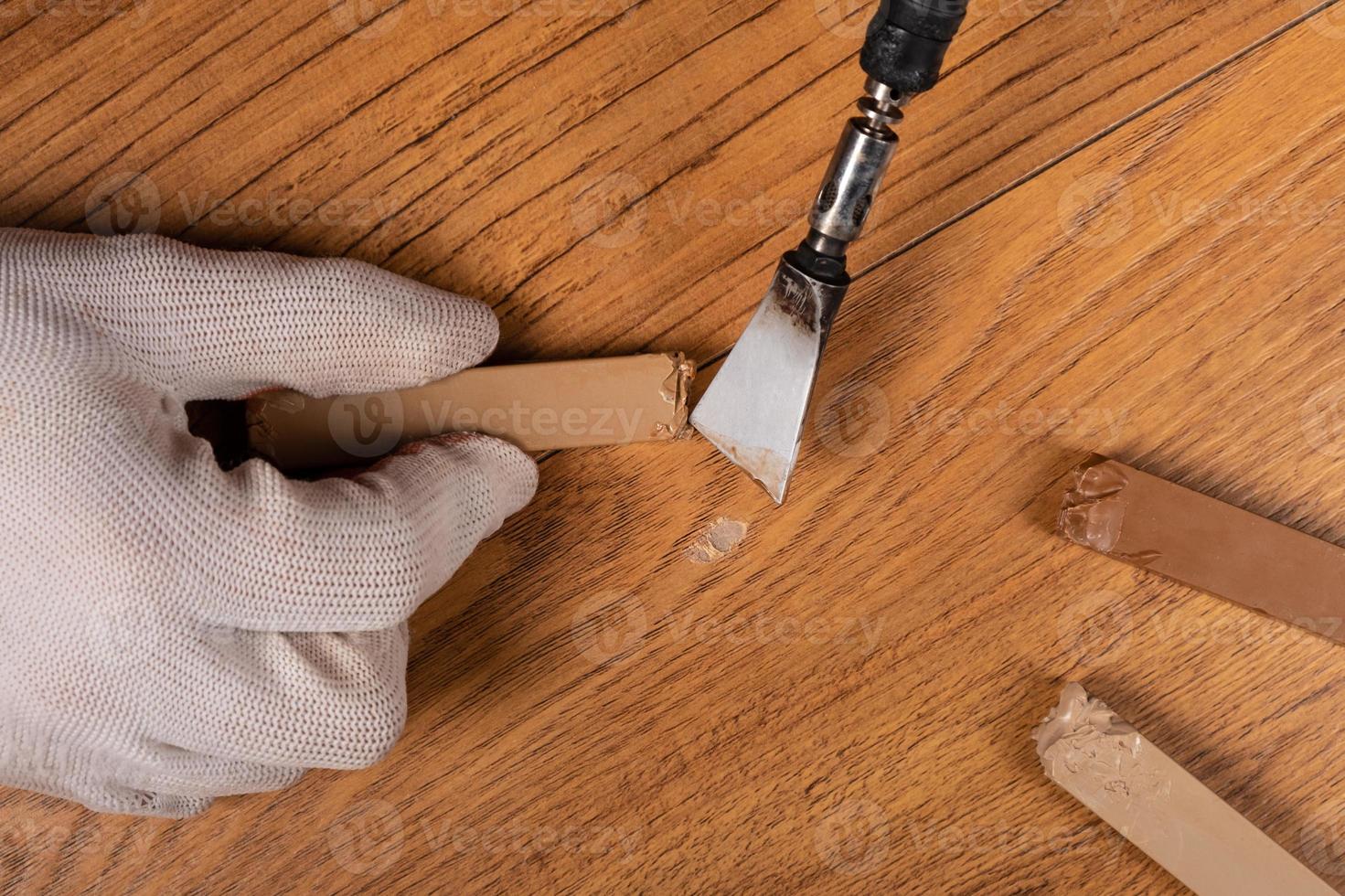 che fissa un graffio su una superficie di legno foto