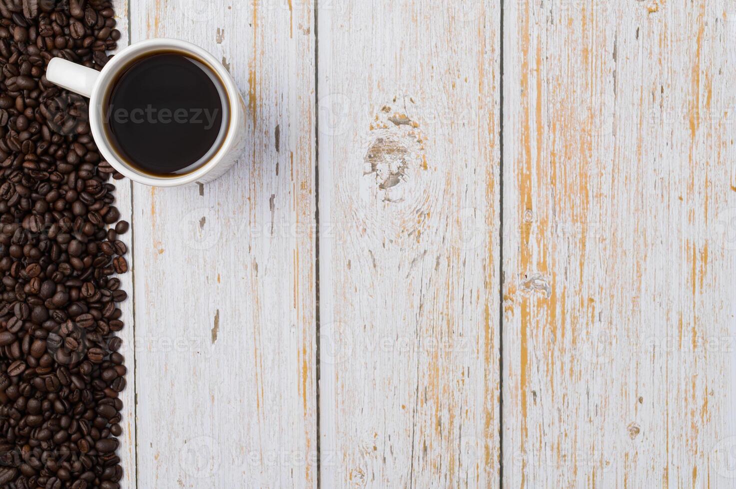 una tazza di caffè e chicchi di caffè su un tavolo di legno foto