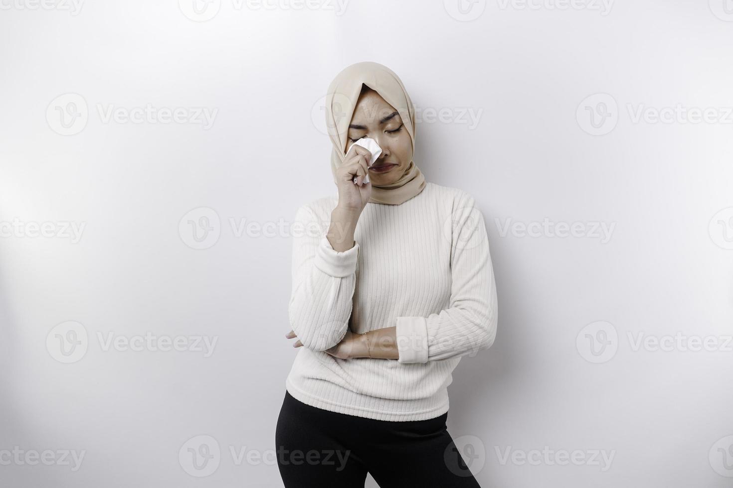 un infelice asiatico musulmano donna indossare un' foulard è asciugandosi sua lacrime nel disperazione, sensazione depresso e solitario. foto