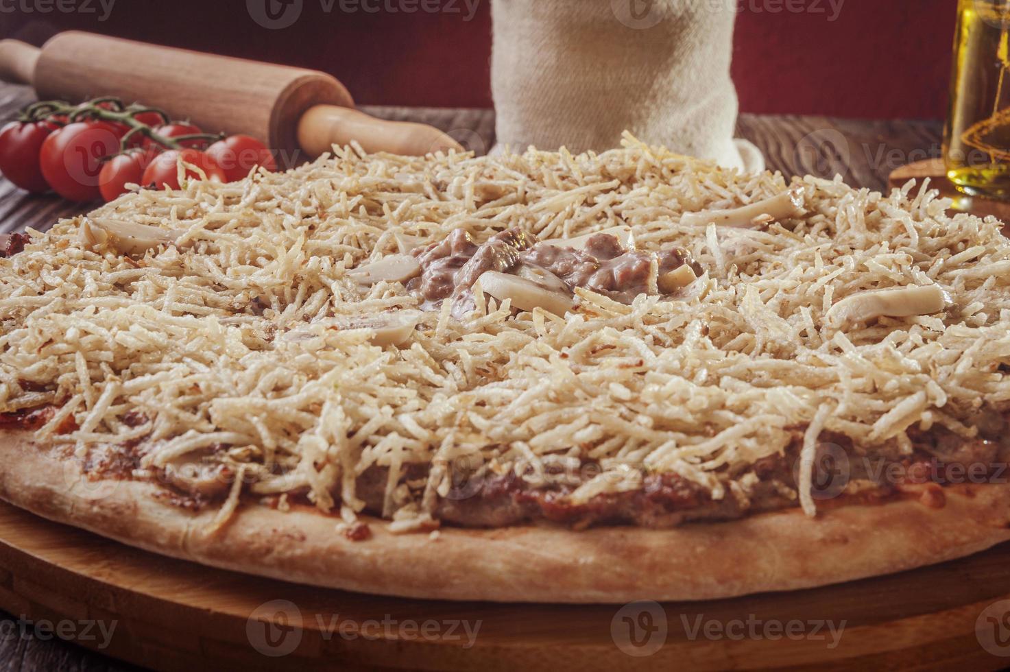 pizza con mozzarella, manzo alla stroganoff e bastoncini di patate foto