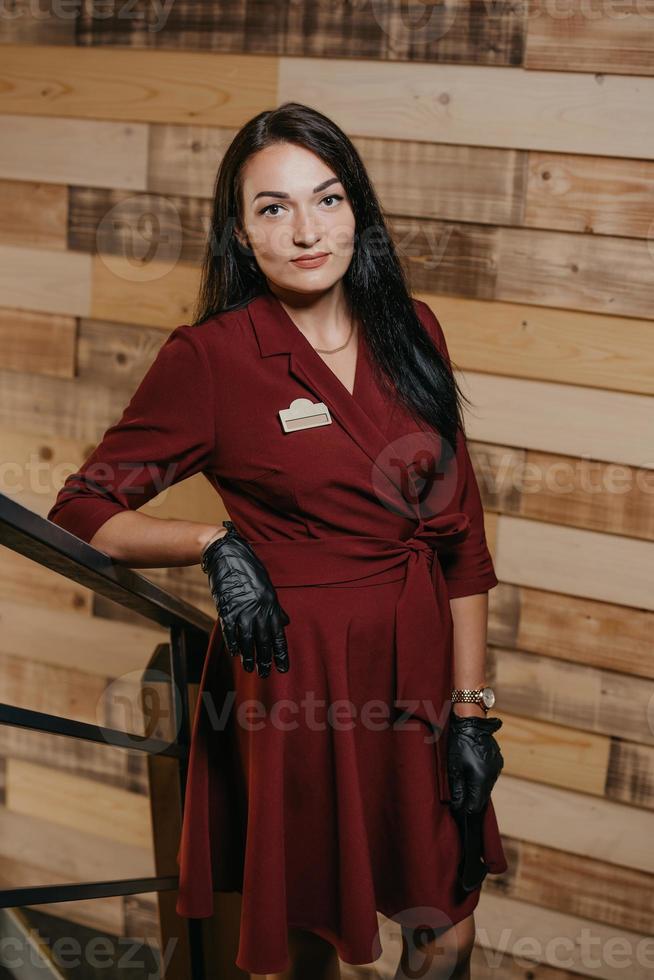 un direttore di ristorante femminile in guanti monouso neri in posa in una caffetteria foto