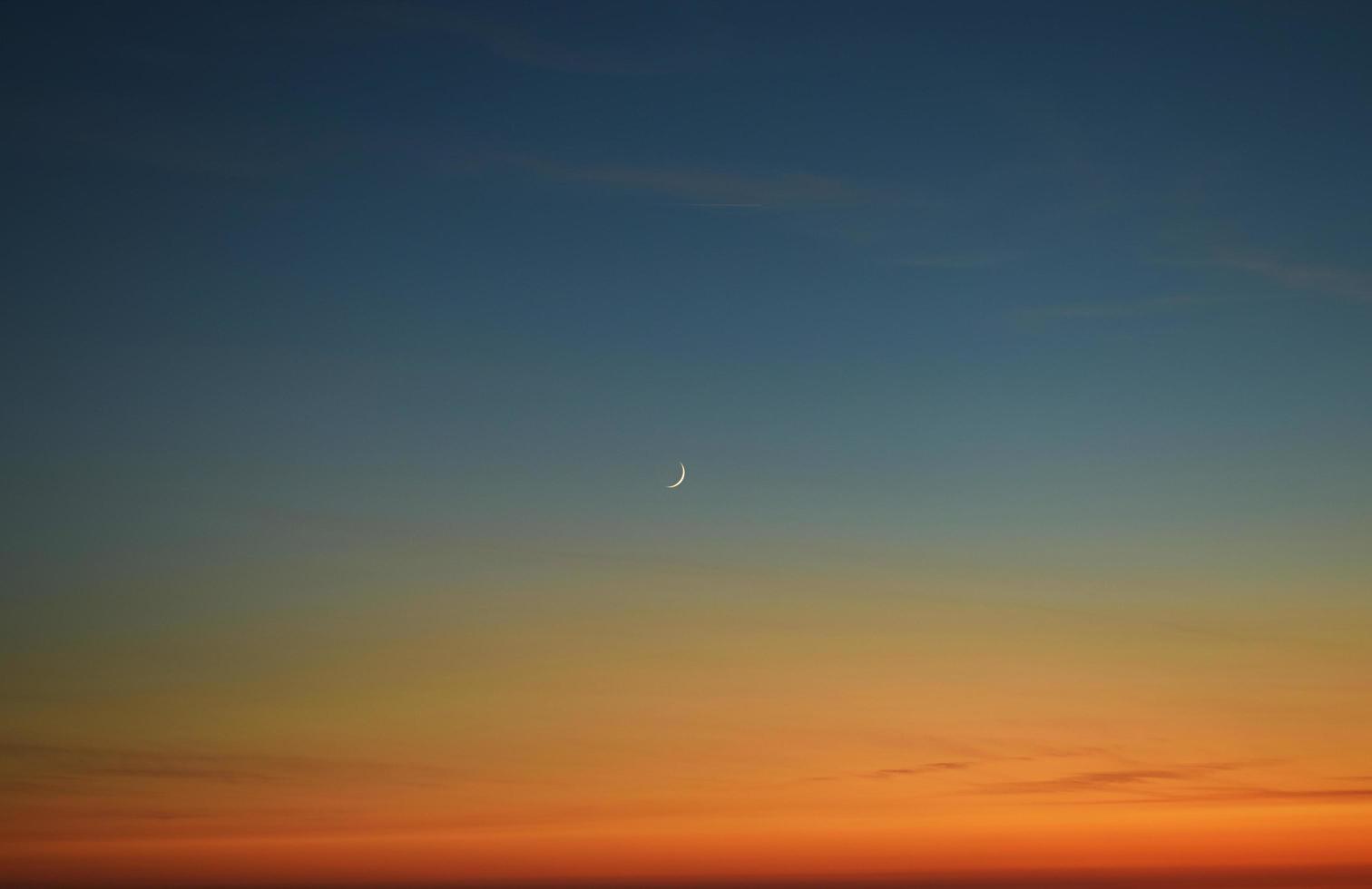 falce di luna durante il tramonto foto
