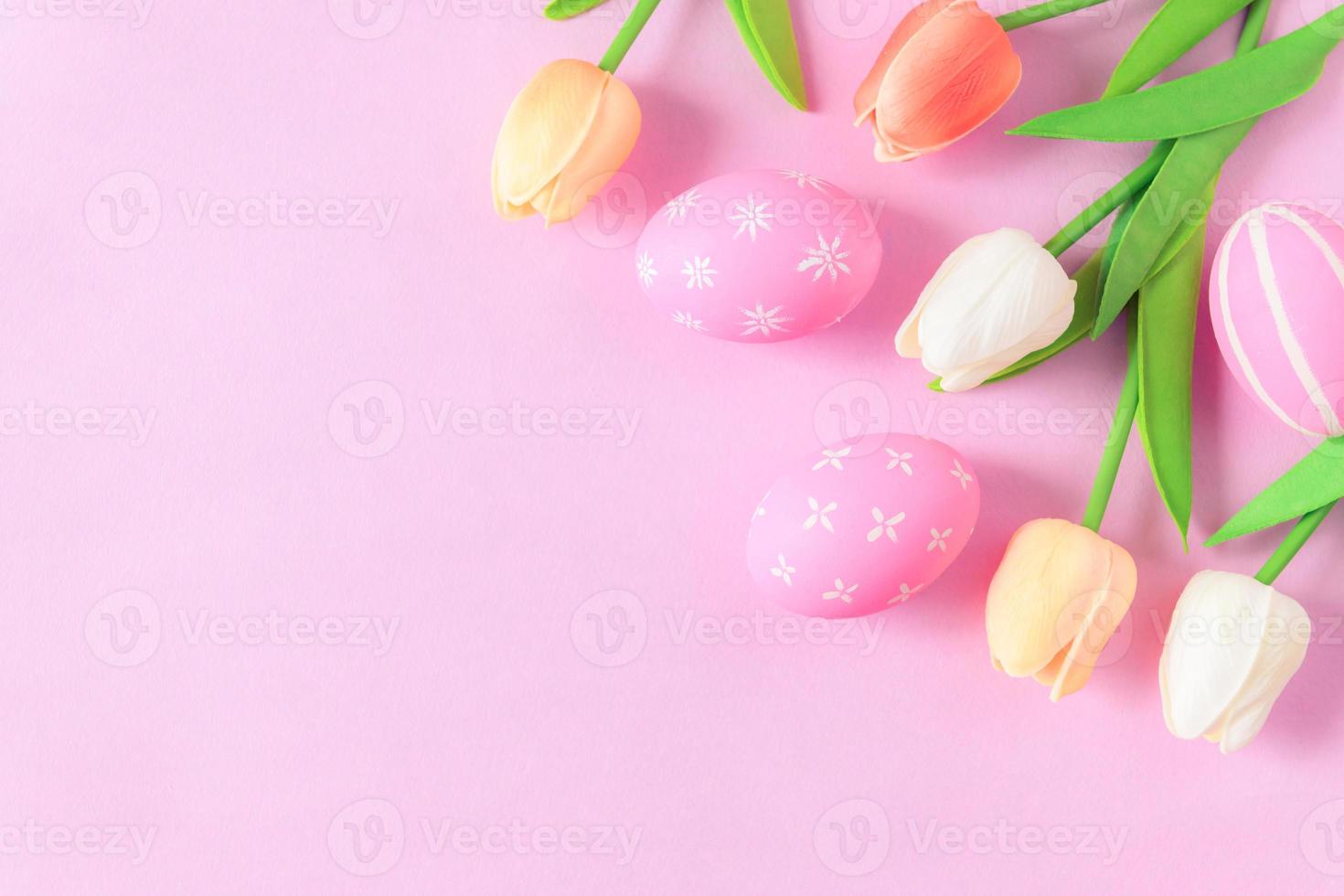 contento Pasqua vacanza saluto carta concetto. colorato Pasqua uova e primavera fiori su pastello rosa sfondo. piatto posizione, superiore Visualizza, copia spazio. foto