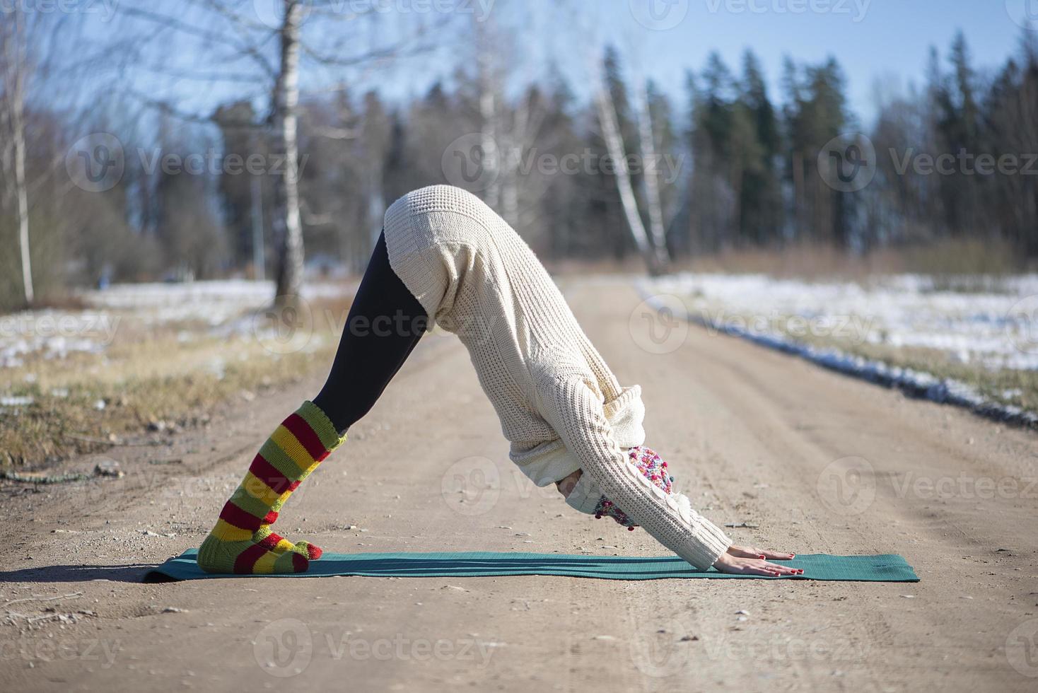 una giovane donna atletica esegue esercizi di yoga e meditazione all'aperto foto