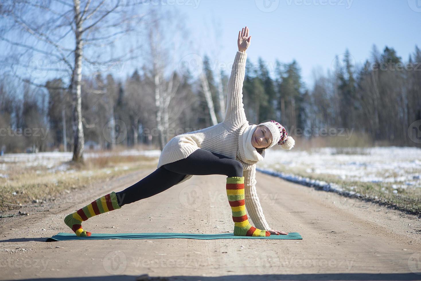 una giovane donna atletica esegue esercizi di yoga e meditazione all'aperto foto