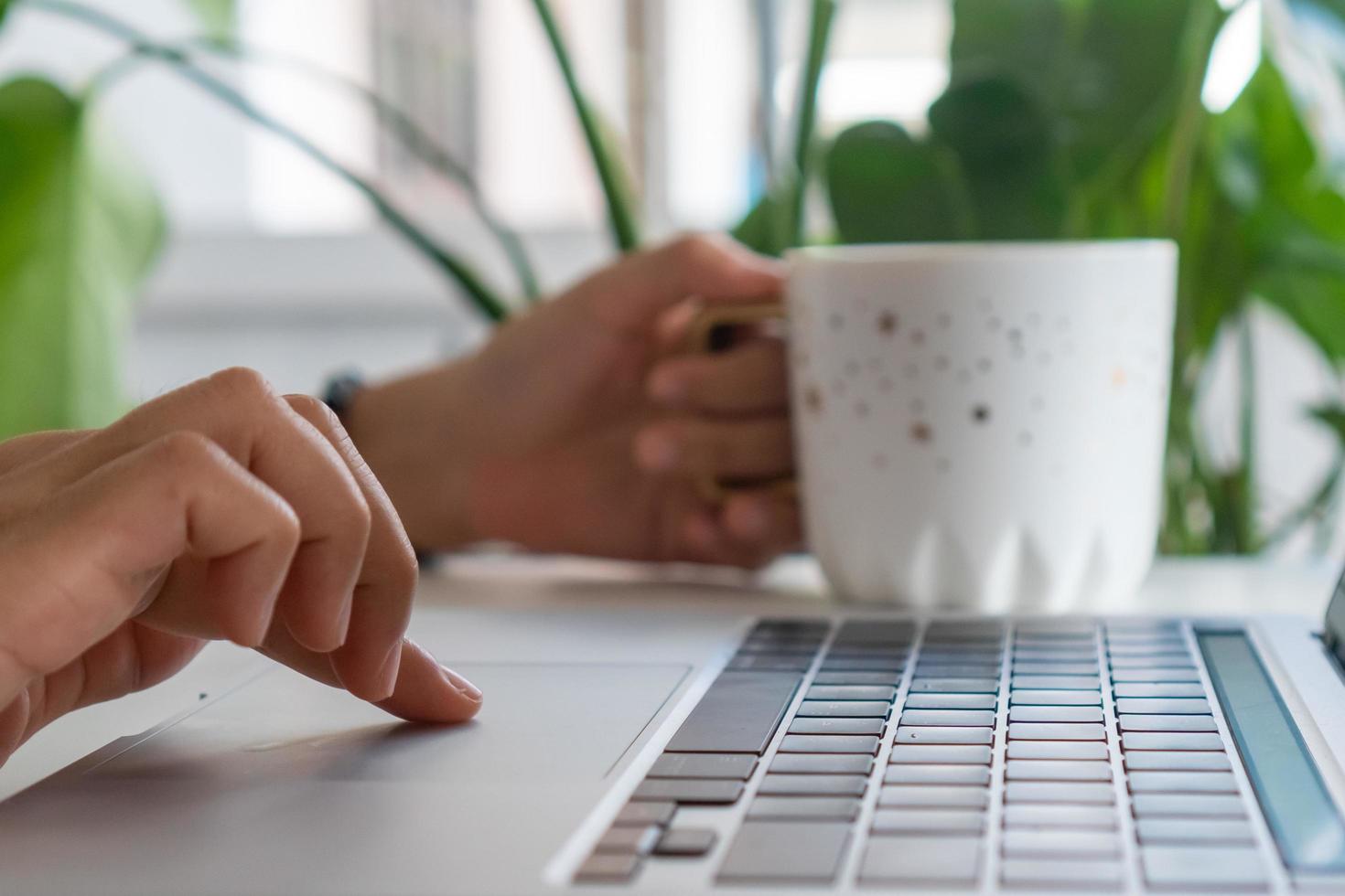 una mano che utilizza un computer portatile alla ricerca di informazioni su Internet foto