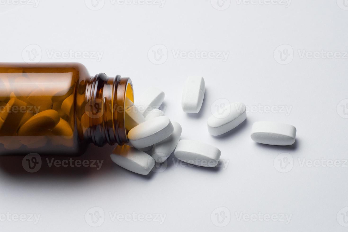 medicina pillola tavoletta con rovesciato bottiglia, bianca sfondo foto