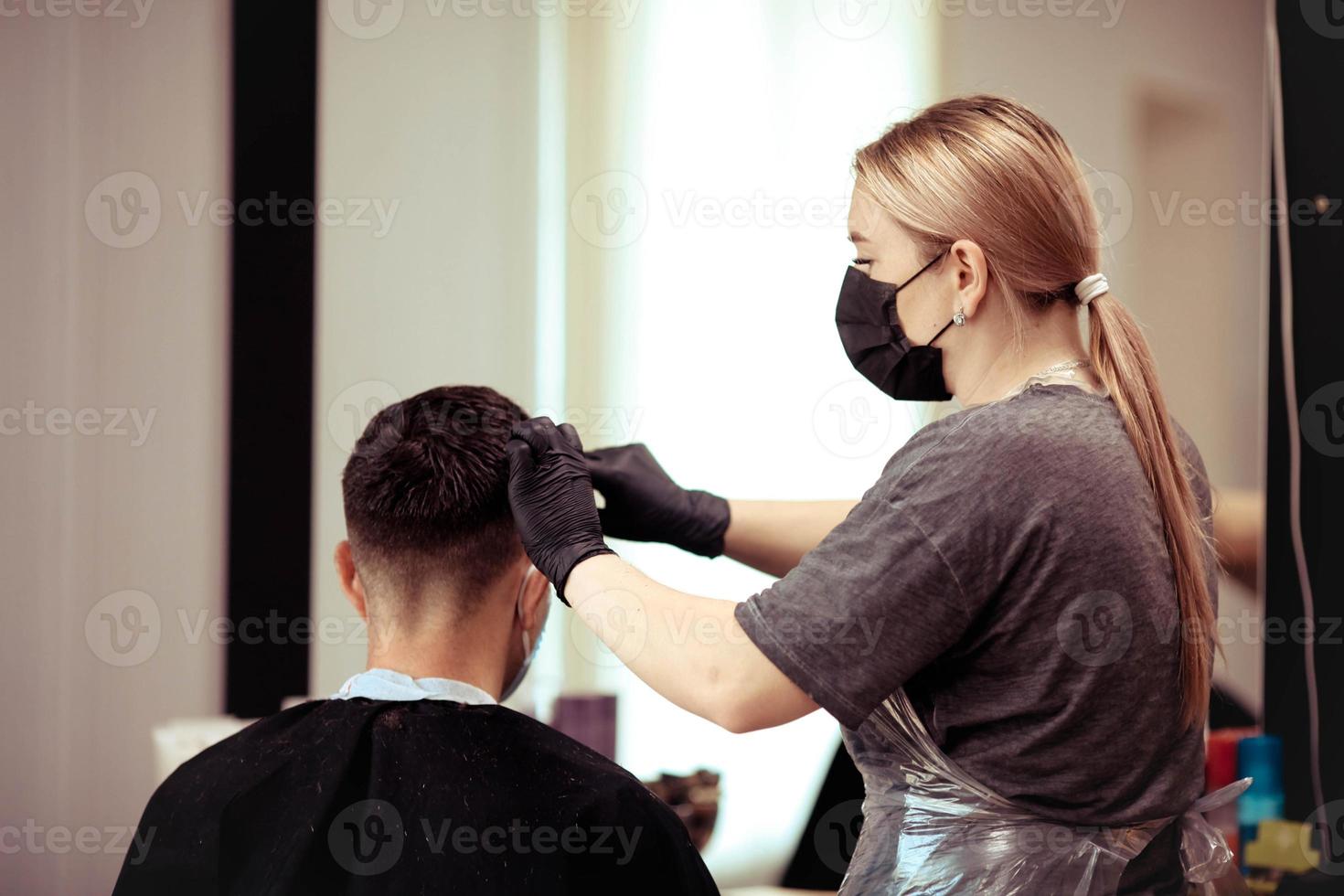 vicino su parrucchiere con sicurezza le misure per covid19, tagli un' uomo sociale distanza, taglio capelli con un' medico maschera. foto