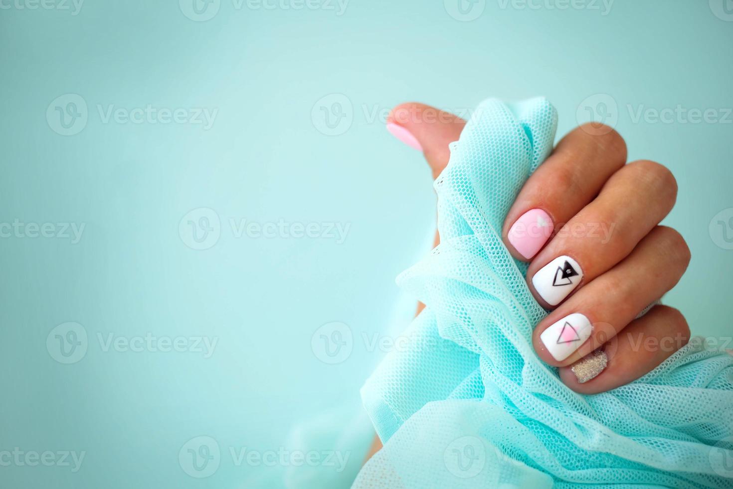 femmina mani con un' bellissimo manicure su un' blu sfondo. foto