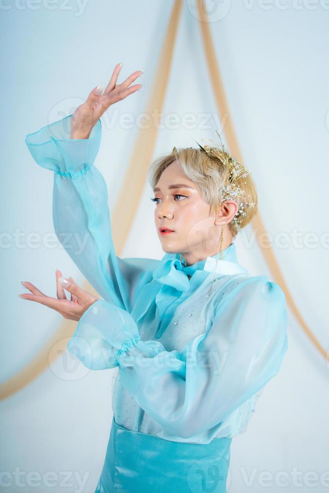 vicino su foto di un asiatico donna con corto bionda capelli e indossare un' blu vestito