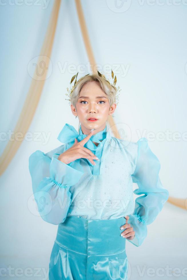 un elegante donna con bionda capelli indossare un' d'oro corona e un' blu vestito foto