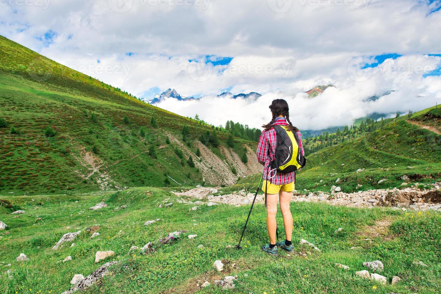 ragazza in un prato di montagna durante una passeggiata foto