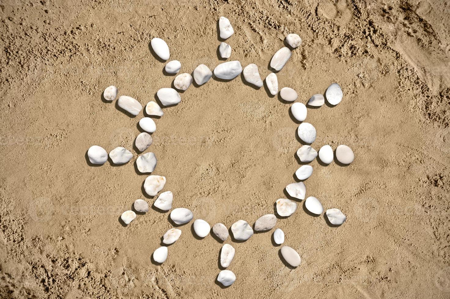 sole forma fatto con pietre su sabbia foto