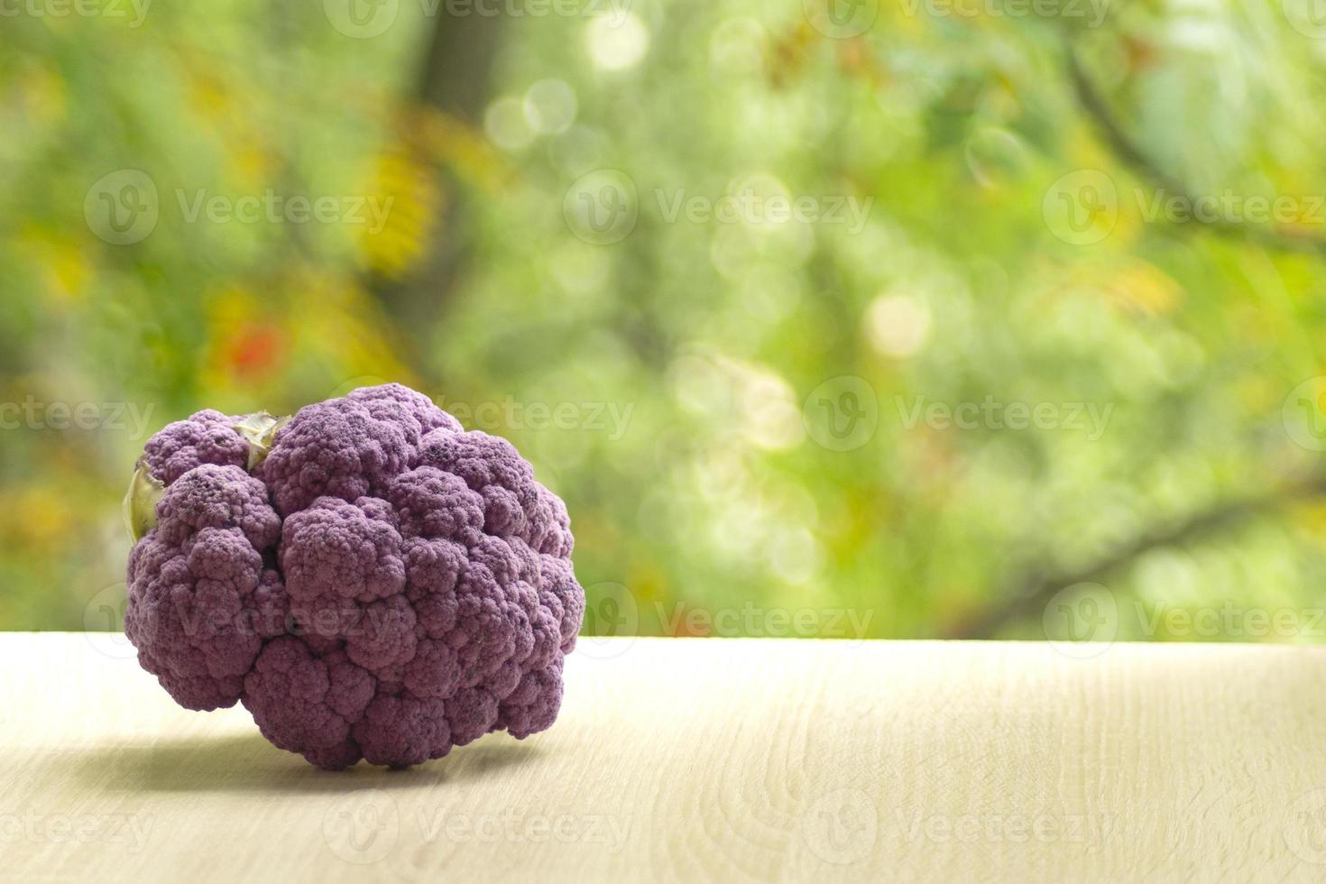 fresco maturo viola cavolfiore. salutare cibo su tavolo su defocus autunno sfondo. foto