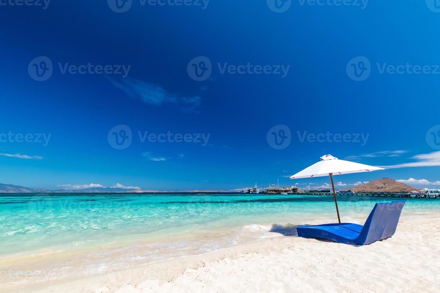 lettini con ombrellone sulla spiaggia di sabbia vicino al mare foto