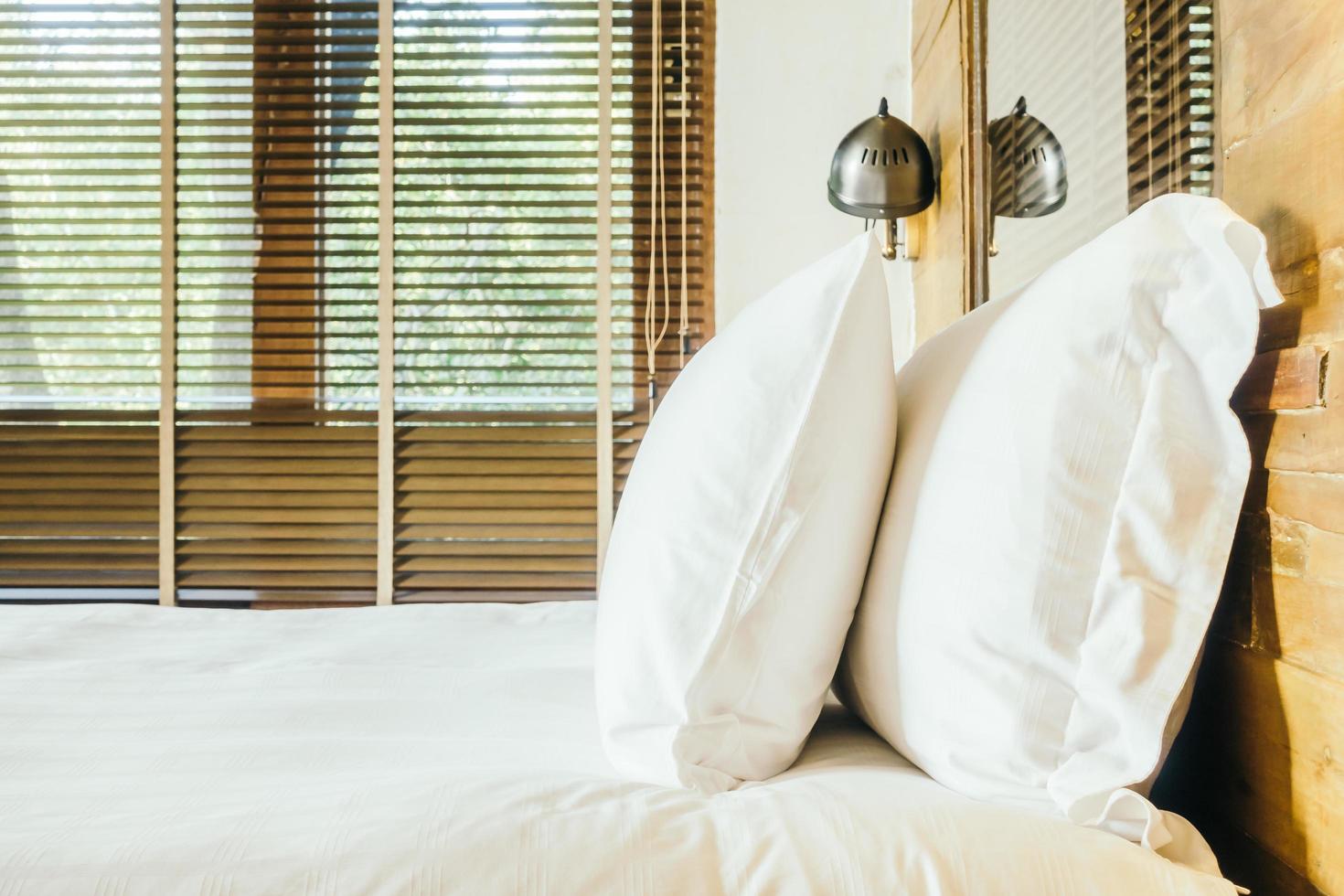 cuscino bianco sul letto in camera da letto foto