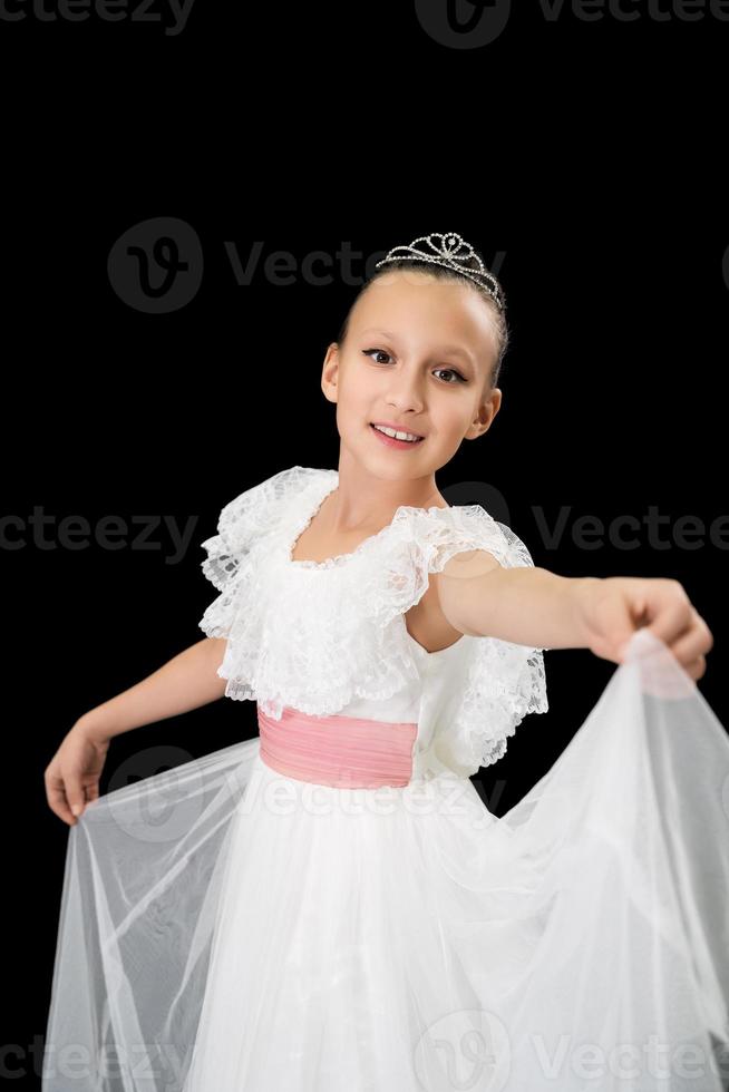 ragazza balletto ballerino con diadema su testa vestito nel bianca lungo vestito danza su nero sfondo foto