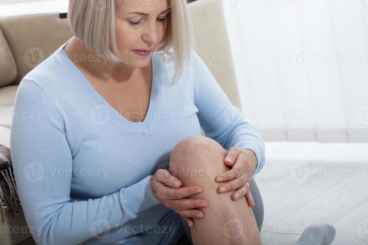 di mezza età donna sofferenza a partire dal dolore nel gamba a casa, avvicinamento. fisico infortunio concetto. foto
