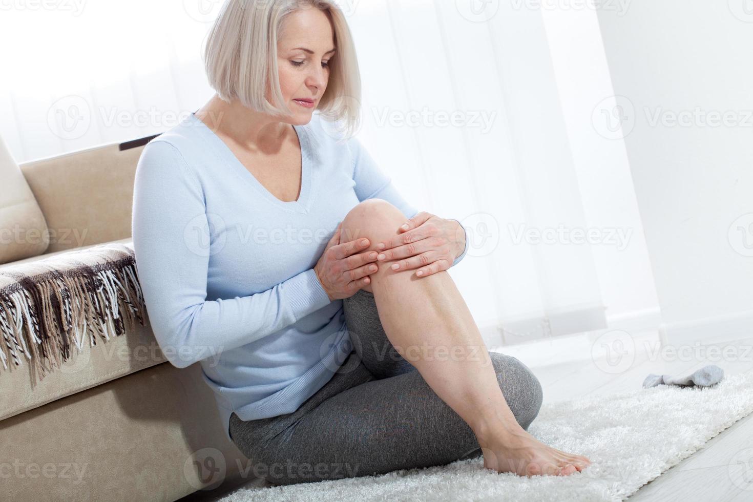 di mezza età donna sofferenza a partire dal dolore nel gamba a casa, avvicinamento. fisico infortunio concetto. foto