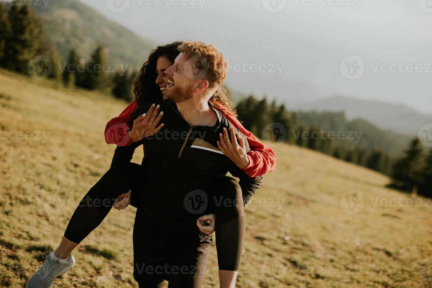 giovane donna equitazione a cavalluccio su un' fidanzato a verde colline foto