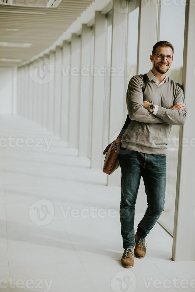 giovane moderno uomo d'affari in piedi nel il ufficio corridoio foto