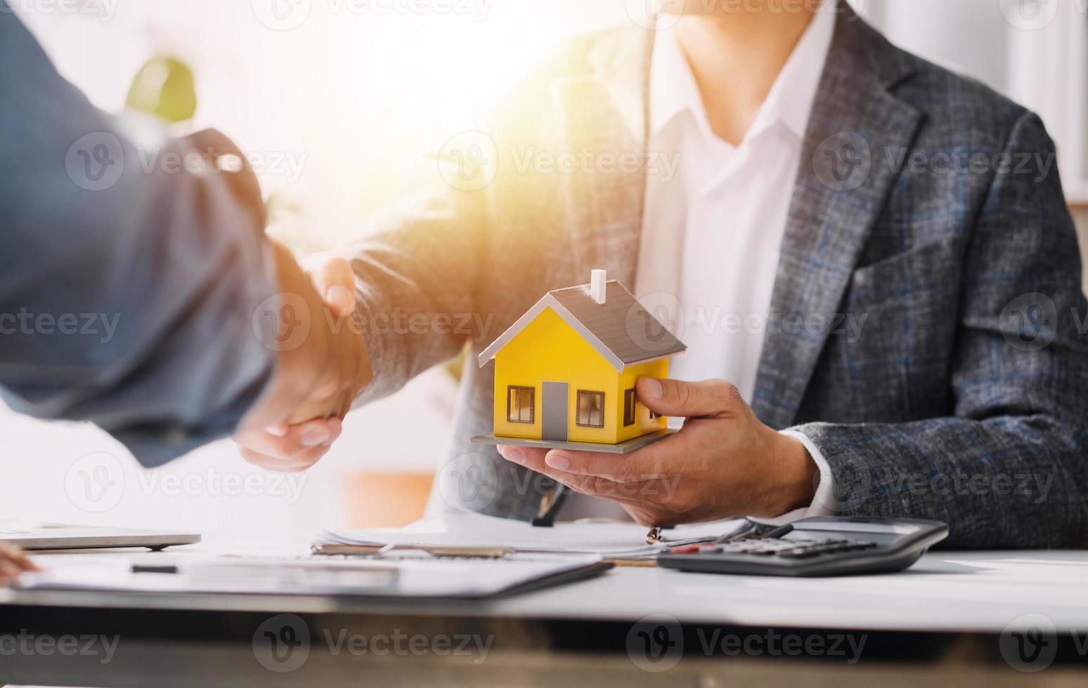 agente di intermediazione immobiliare che presenta e consulta il cliente per prendere decisioni firmare un contratto di assicurazione, acquistare e vendere modello di casa, riguardante l'offerta di mutuo ipotecario e l'assicurazione sulla casa foto