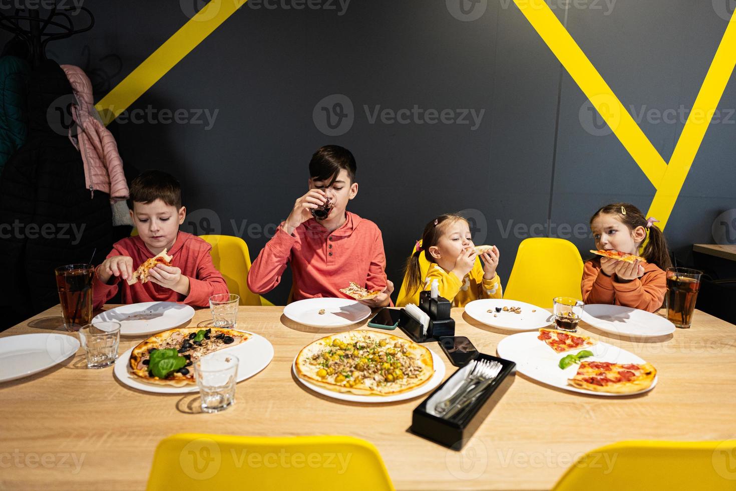 quattro bambini mangiare italiano Pizza nel pizzeria. bambini mangiare a bar. foto