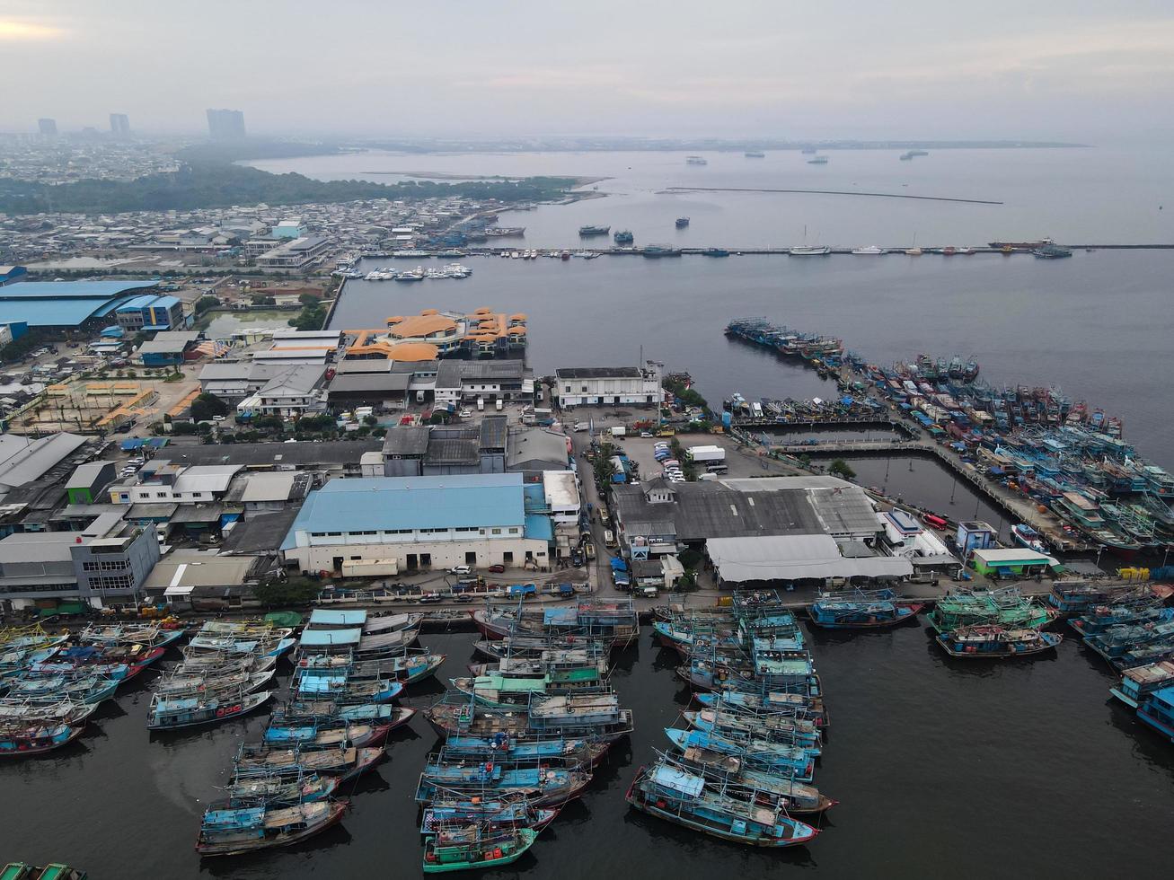 jakarta, indonesia 2021- veduta aerea con drone della spiaggia di muara angke con barche di legno appoggiate al molo foto