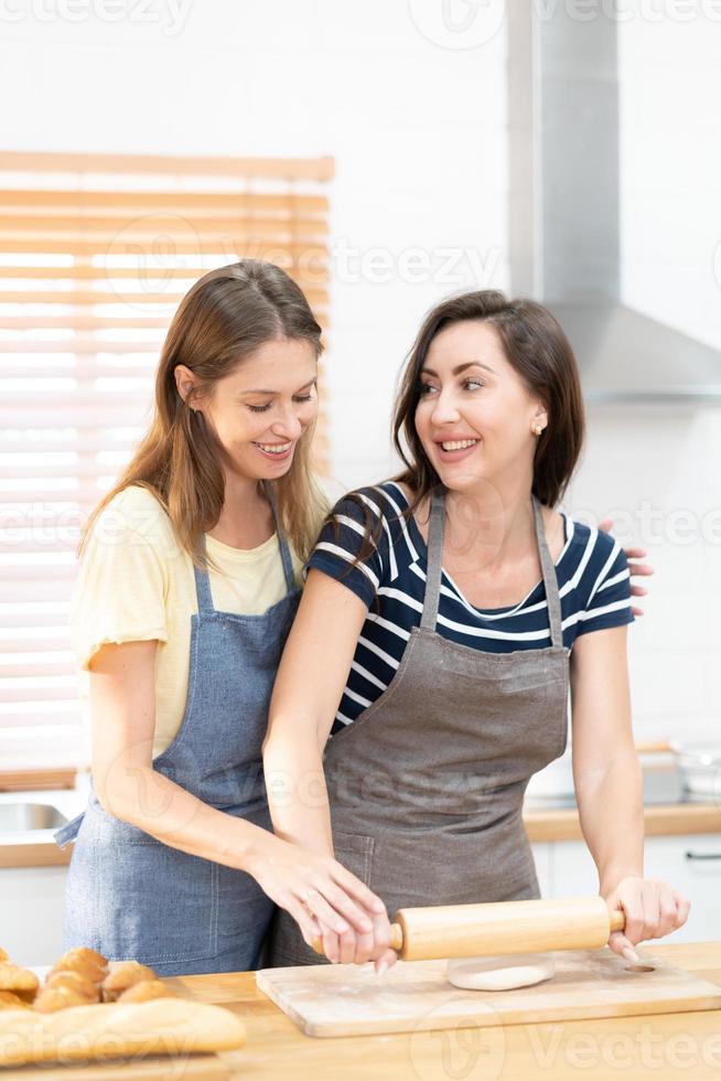 Due caucasico donne cucinando Pizza insieme nel il cucina. il concetto di casa cucinato cibo e lgbt relazioni. famiglia e diversità concetto. lgbt amore. foto