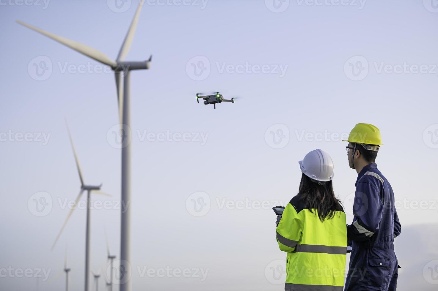 Due ingegneri Lavorando e Tenere il rapporto a vento turbina azienda agricola energia Generatore stazione su montagna, Tailandia gente, tecnico uomo e donna discutere di opera ,utilizzo fuco Visualizza a partire dal alto angolo foto