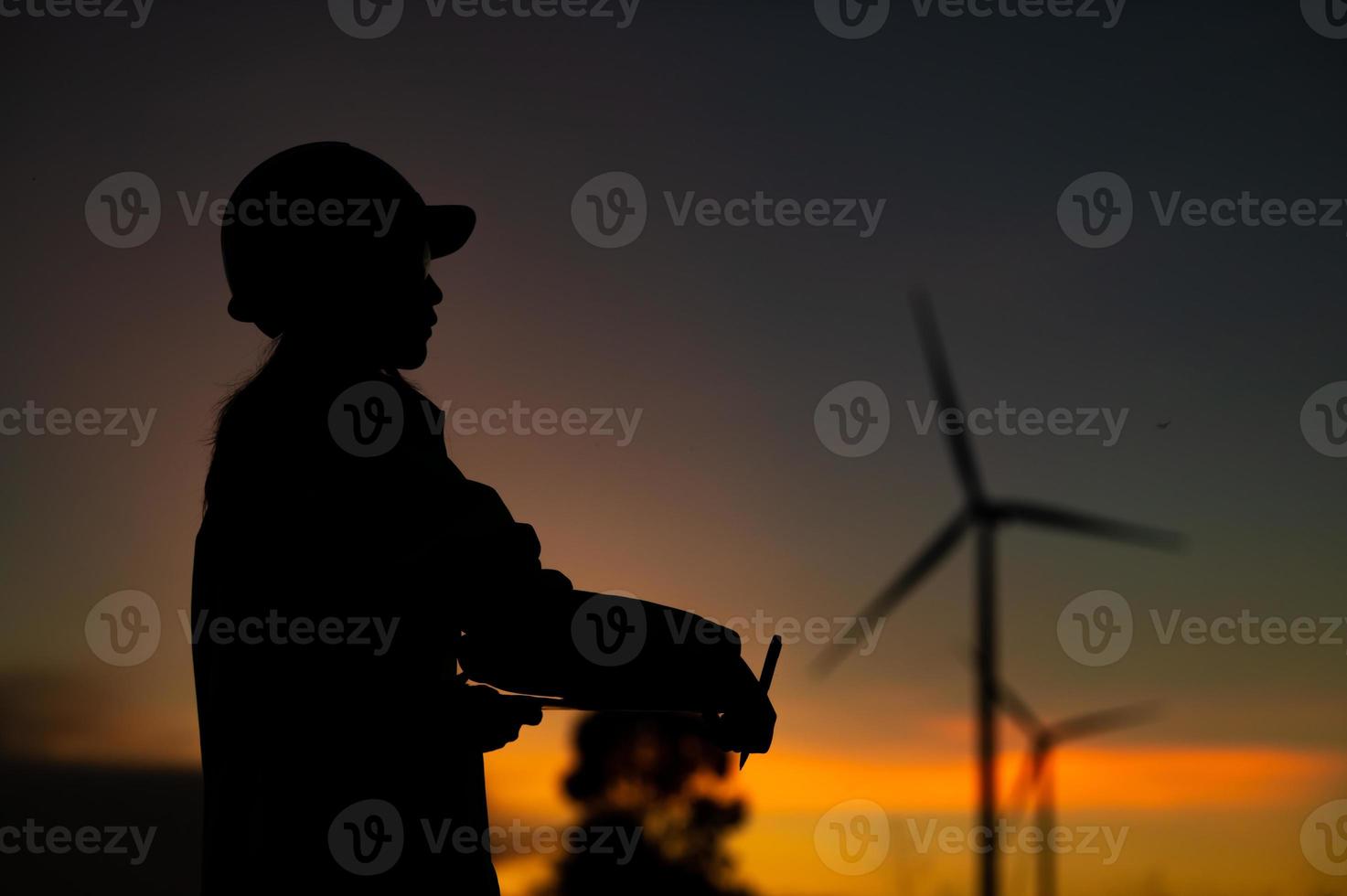 ingegneri dell'uomo asiatico che lavorano e tengono il rapporto presso la stazione del generatore di energia dell'azienda agricola della turbina eolica sulla montagna, la gente della Tailandia, l'uomo tecnico sul sito di lavoro foto