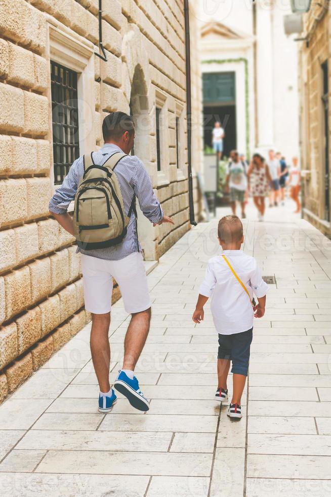 padre e figlio che camminano per la strada della città vecchia durante le vacanze estive foto