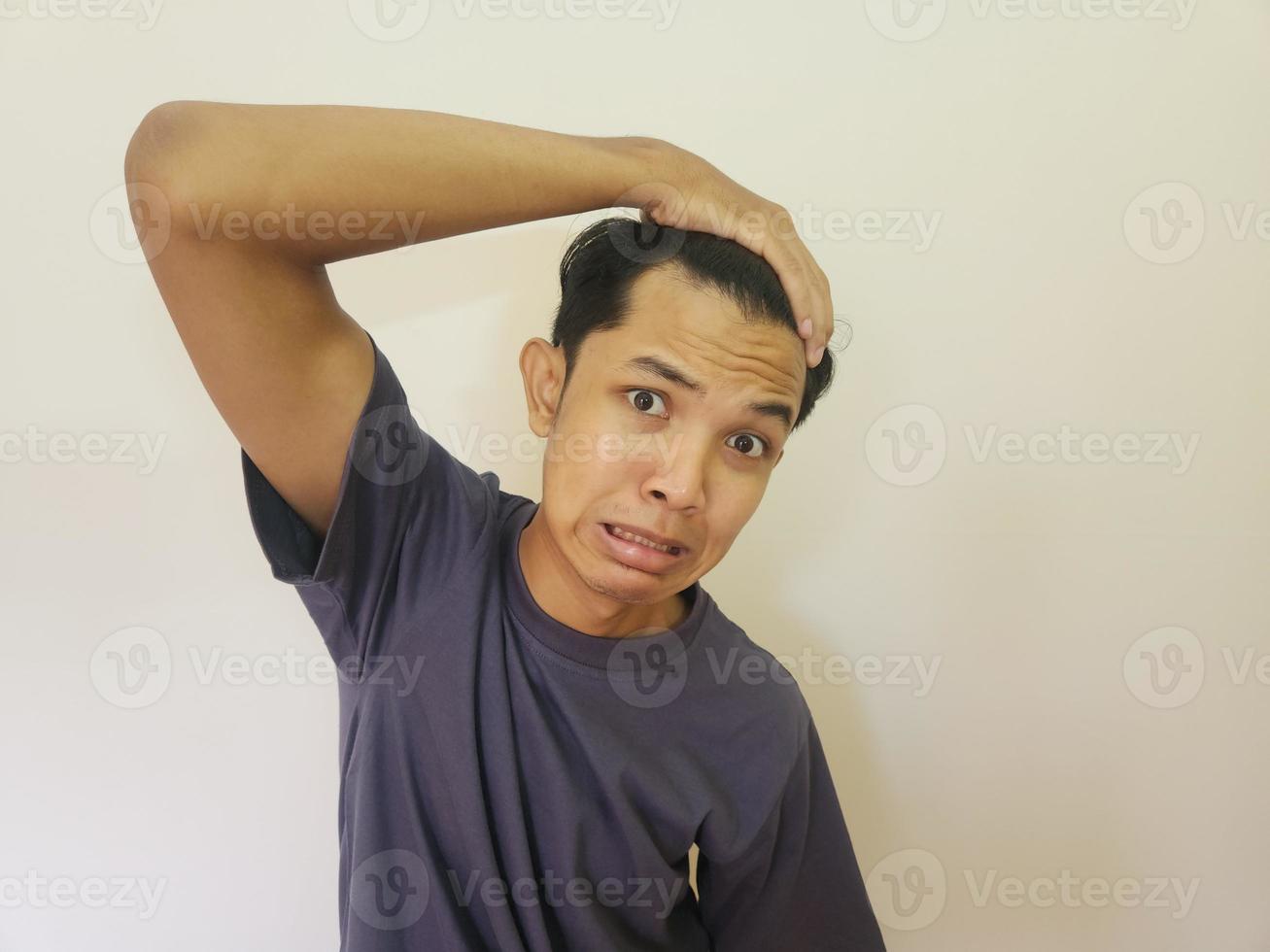 scioccato viso di asiatico uomo ottenere Calvo e perso capelli nel isolato bianca sfondo foto
