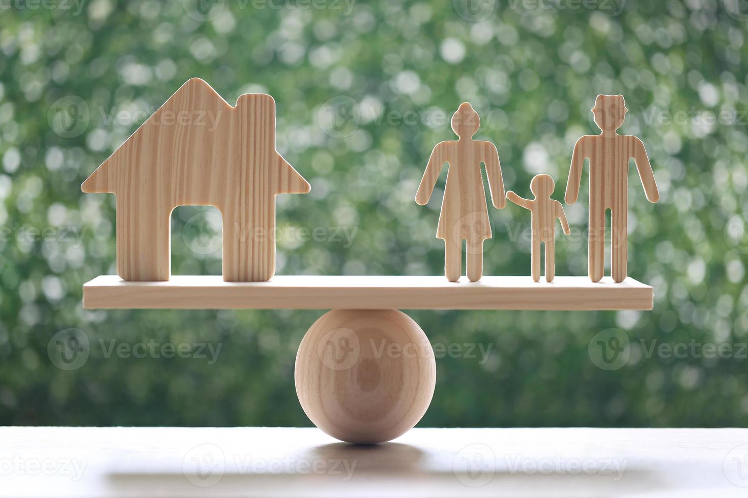 modello di casa e modello di famiglia su altalena in scala di legno con sfondo verde naturale foto