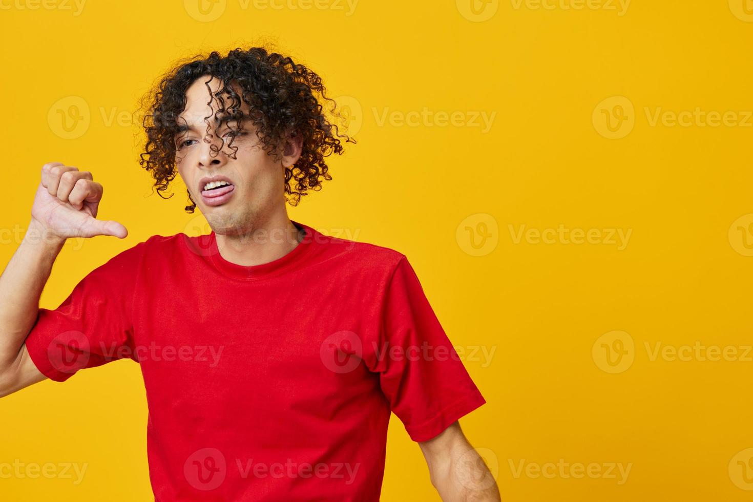 insoddisfatto divertente caucasico giovane uomo nel rosso maglietta mostrare dis piace gesto in posa isolato su giallo studio sfondo. il migliore offrire con gratuito posto per pubblicità. emozioni per ogni giorno concetto foto