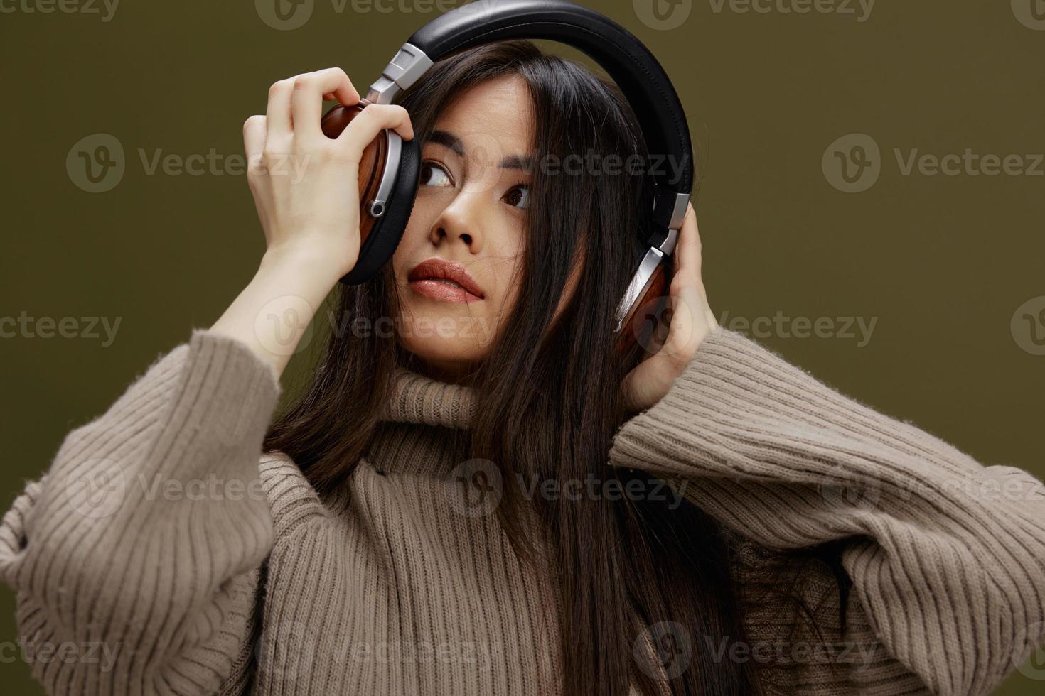 bellissimo donna nel cuffie ascoltando per musica emozioni verde sfondo foto