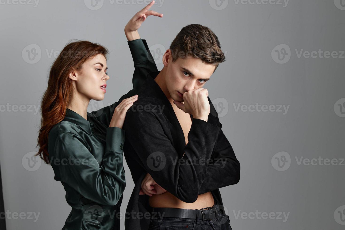 un' donna detiene sua mano sopra il testa di un' sexy uomo nel un' completo da uomo foto